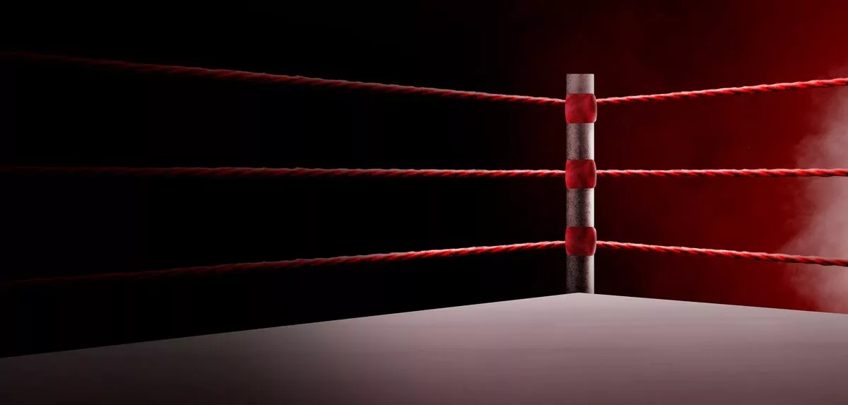 The corner of a boxing ring with red ropes and a red background.
