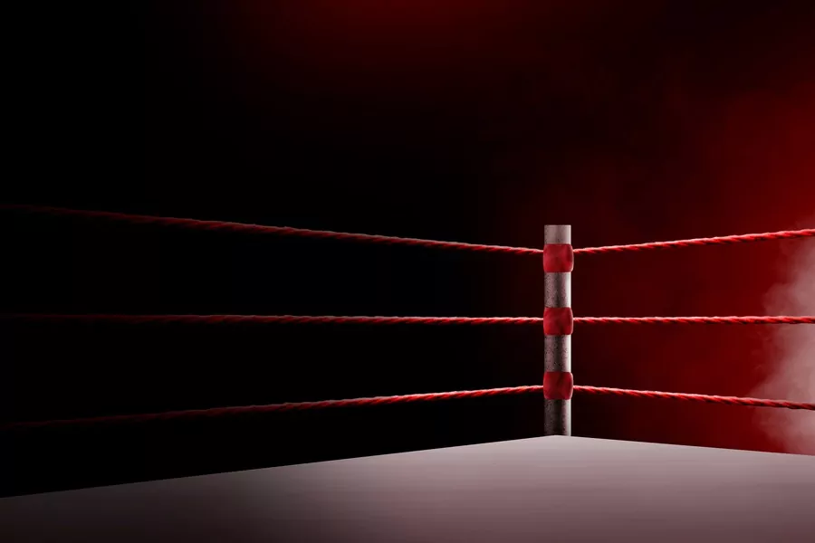 The corner of a boxing ring with red ropes and a red background.
